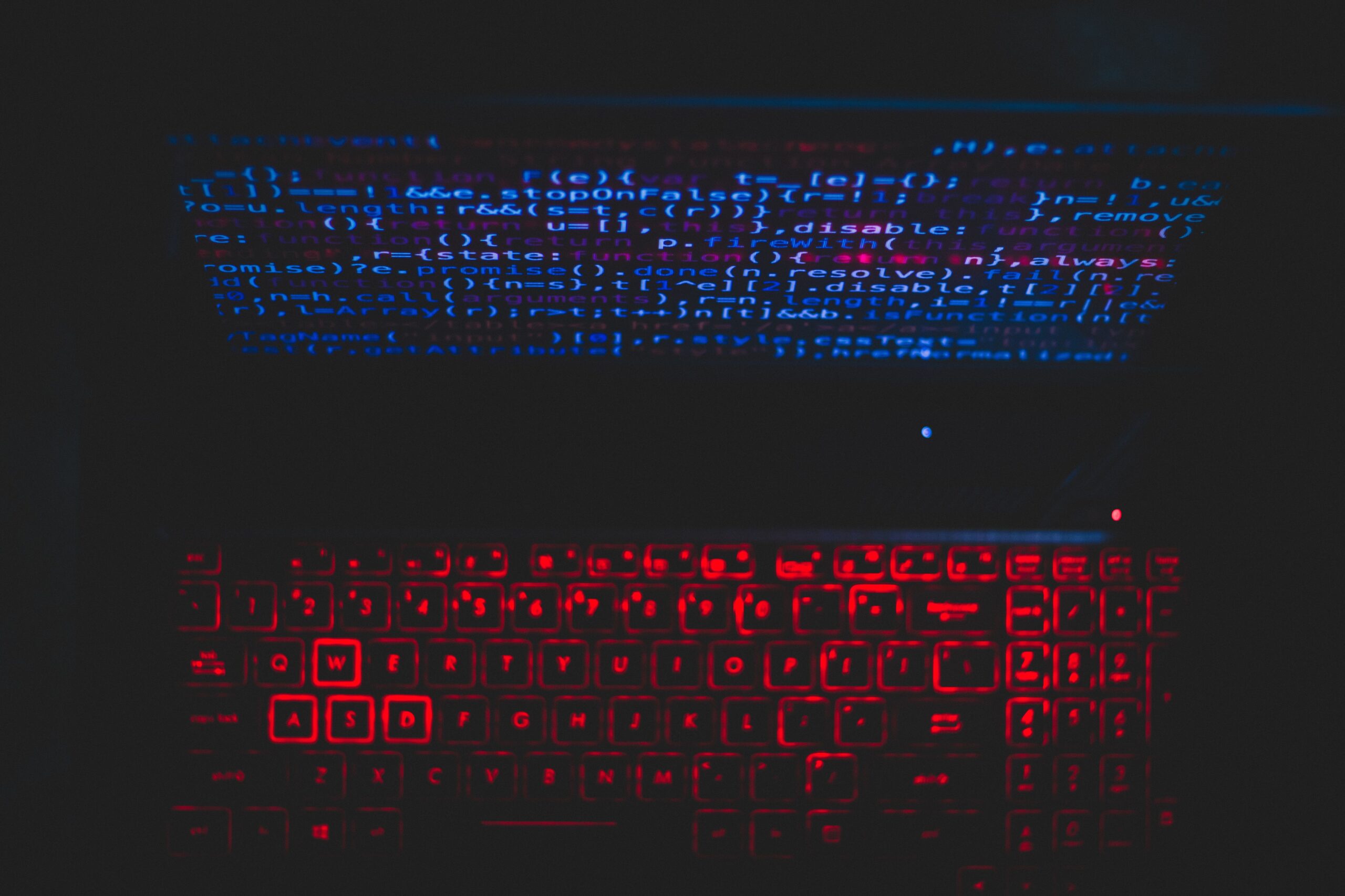 Dark laptop with red keyboard and blue code projections symbolising algorithmic trading failure